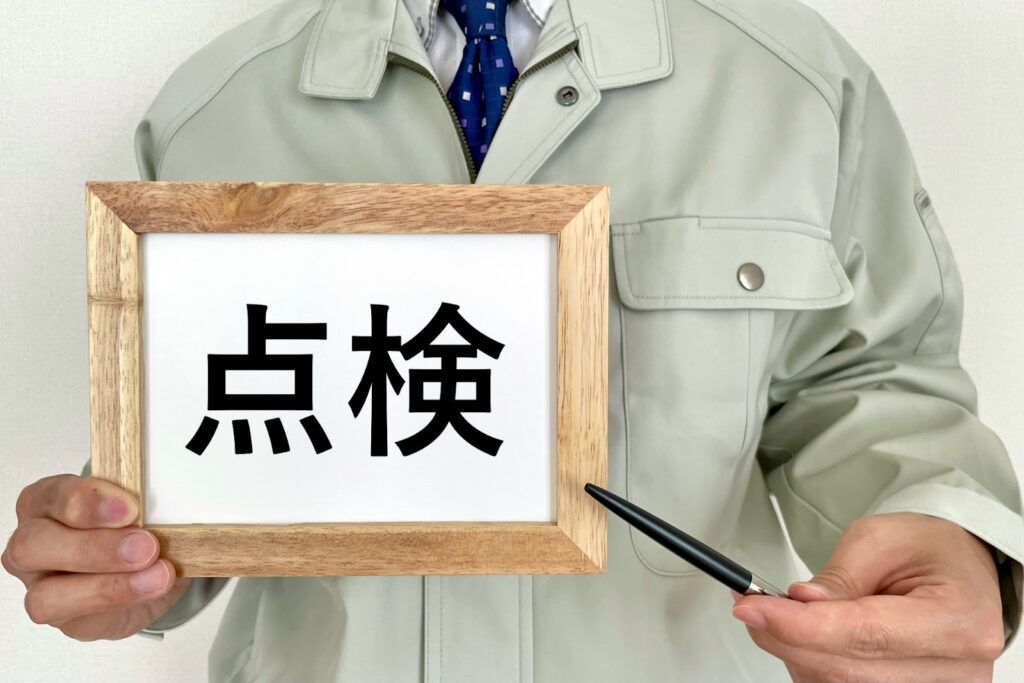 点検と書かれた紙を持っている人の画像